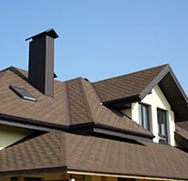 A well-constructed shingle roof of a modern house against a clear blue sky, showcasing the craftsmanship of Sterling Roofing Co., Inc. in Glen Ellen.